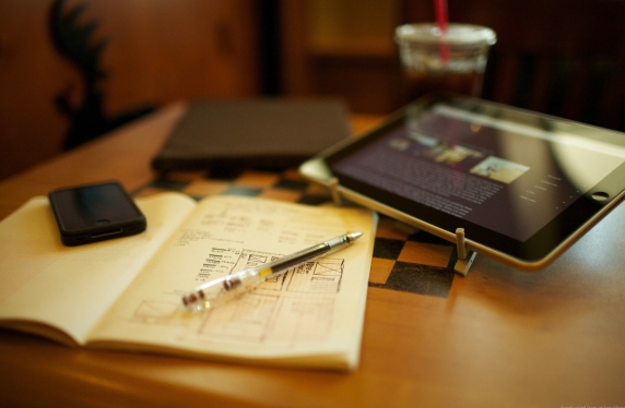 планшет и блокнот на письменном столе и кофе